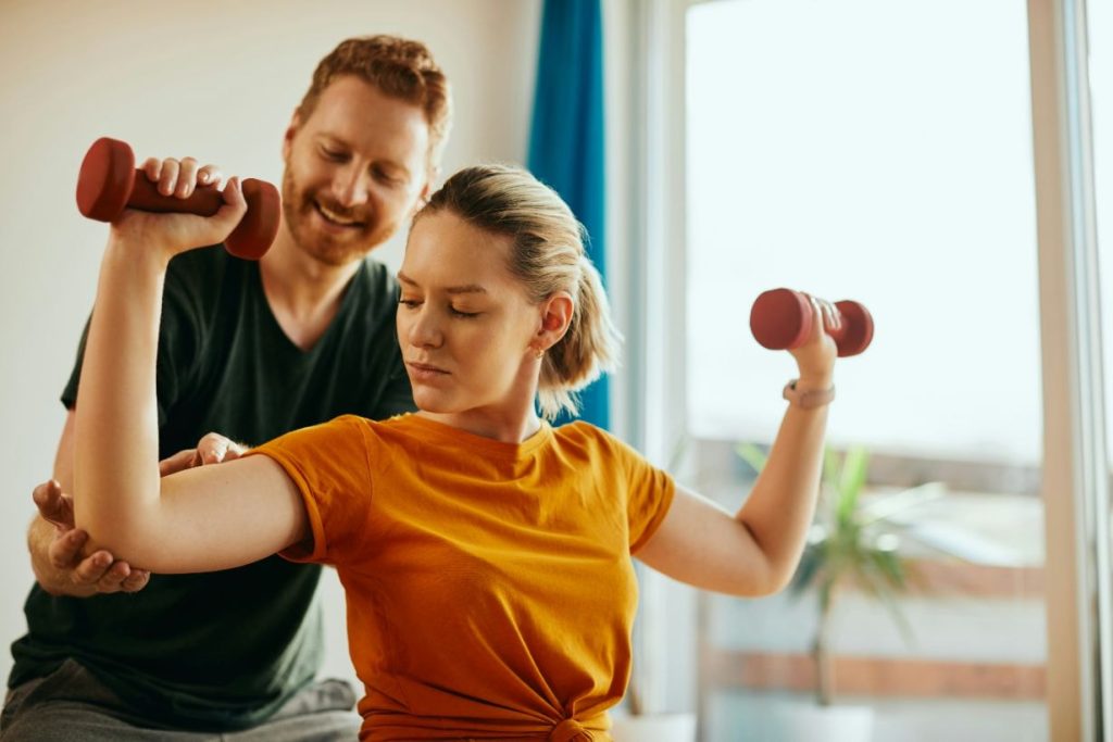 Physio helping lady with weight training