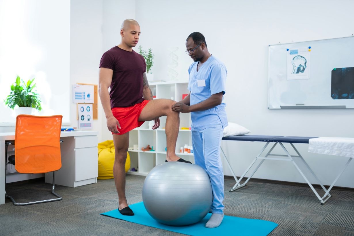 Senior physiotherapist attending to male patient