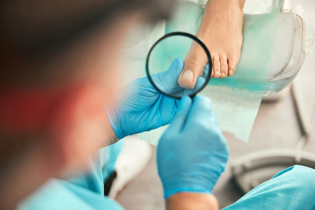 Podiatrist examining feet using magnifying glass